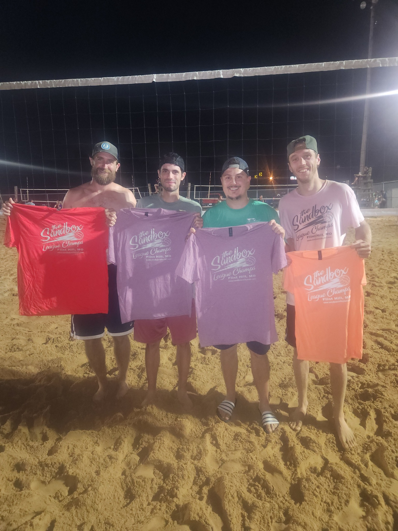 picture of a group of volleyball players wearing the sandbox volleyball logo t-shirts