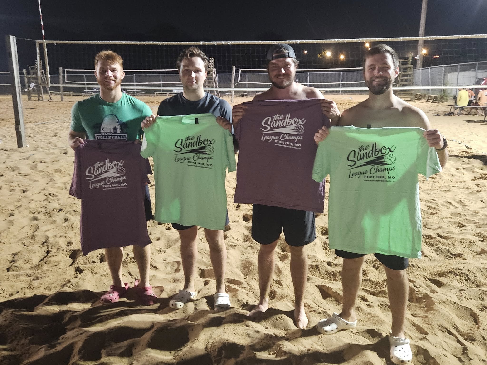 picture of a group of volleyball players wearing the sandbox volleyball logo t-shirts