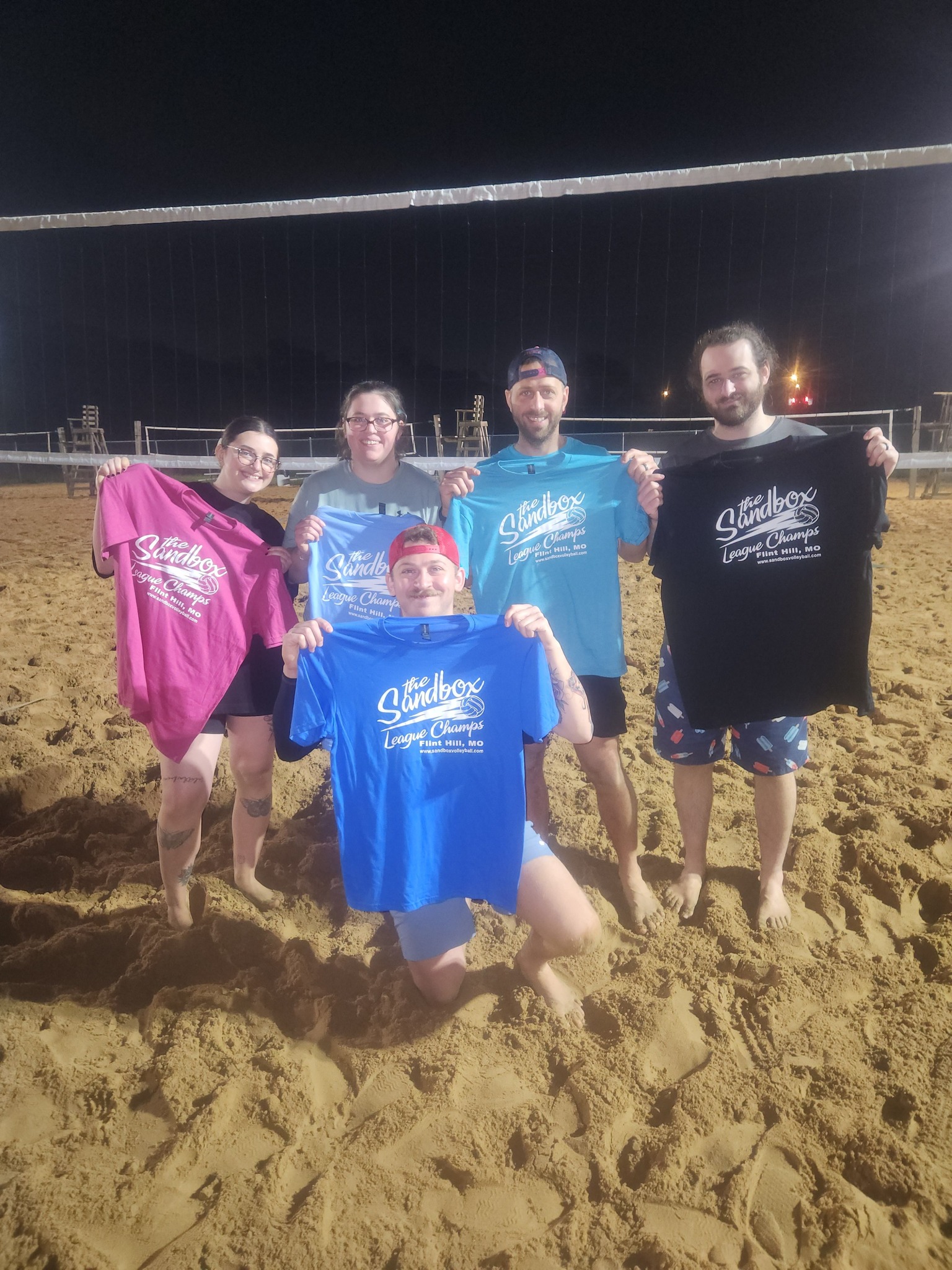picture of a group of volleyball players wearing the sandbox volleyball logo t-shirts