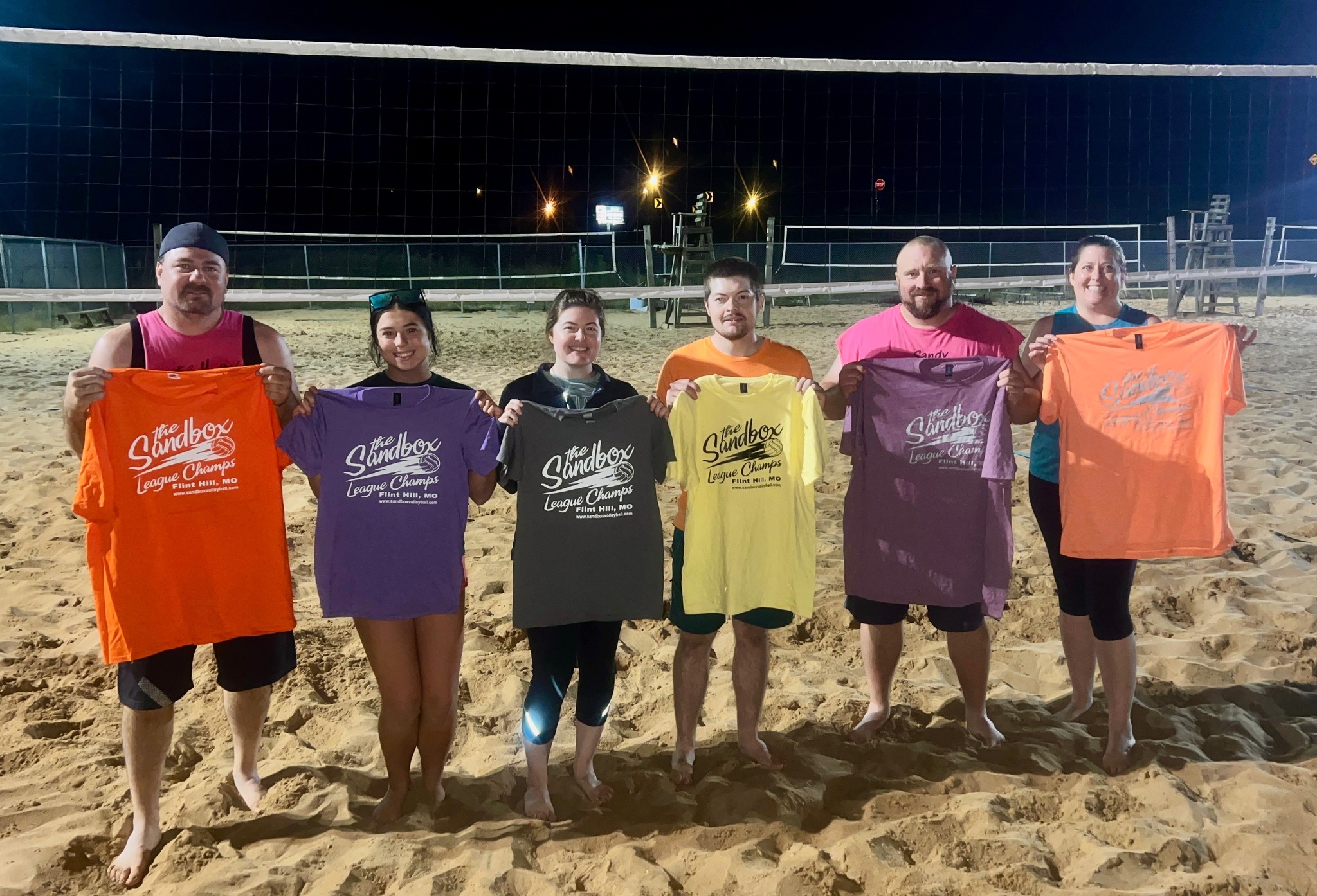 picture of a group of volleyball players wearing the sandbox volleyball logo t-shirts