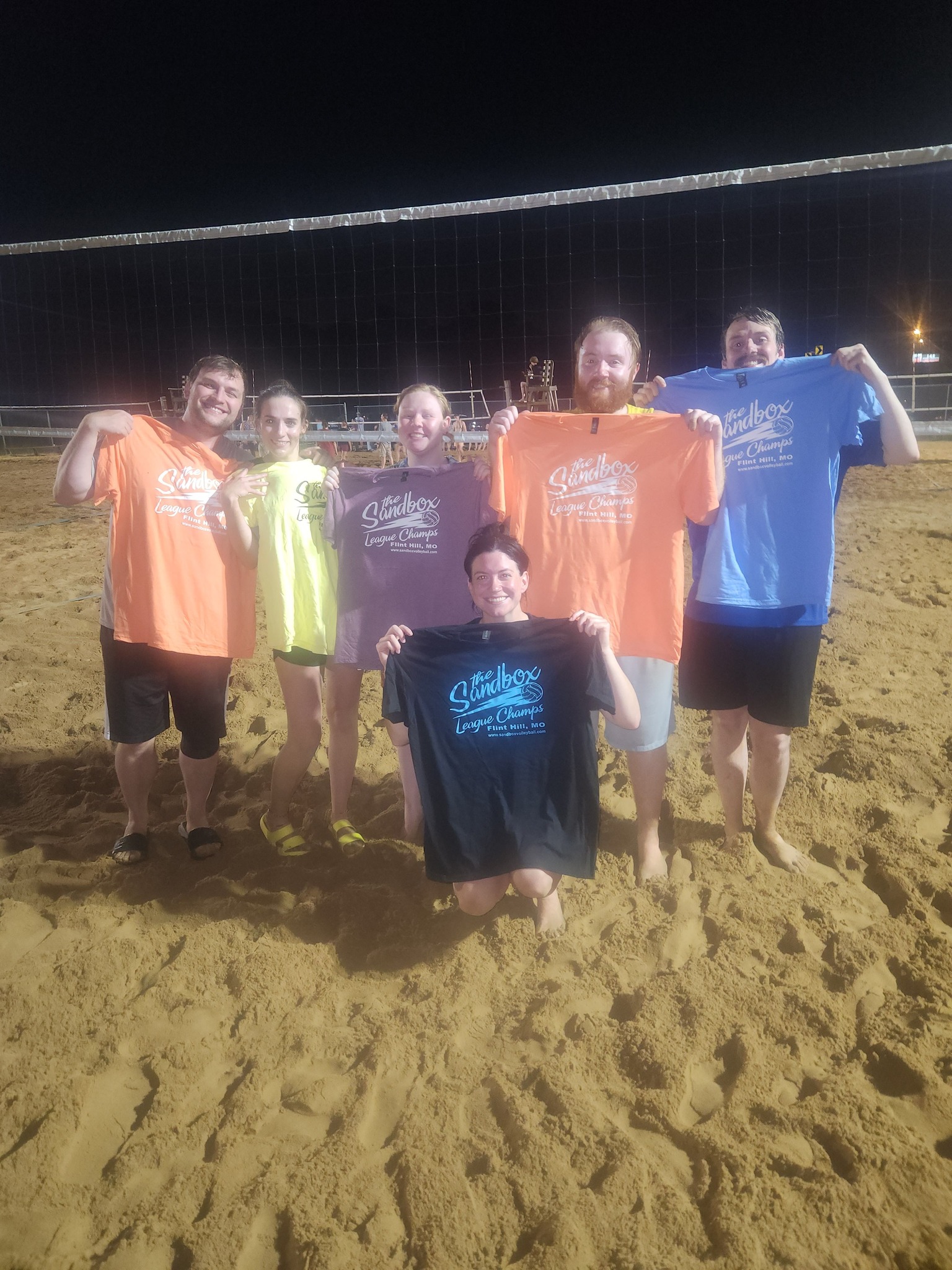 picture of a group of volleyball players wearing the sandbox volleyball logo t-shirts