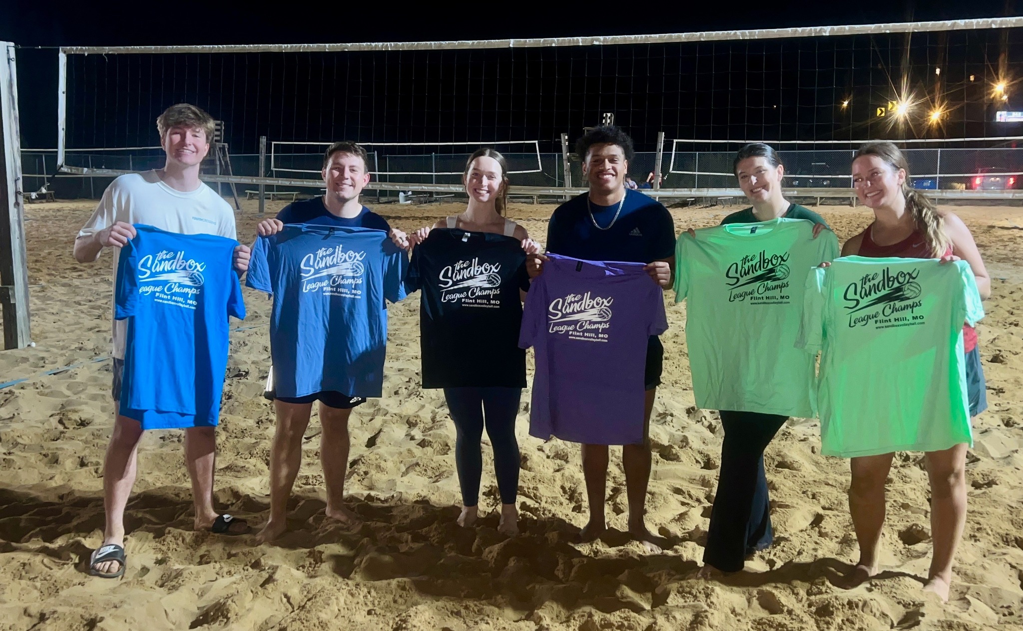 picture of a group of volleyball players wearing the sandbox volleyball logo t-shirts