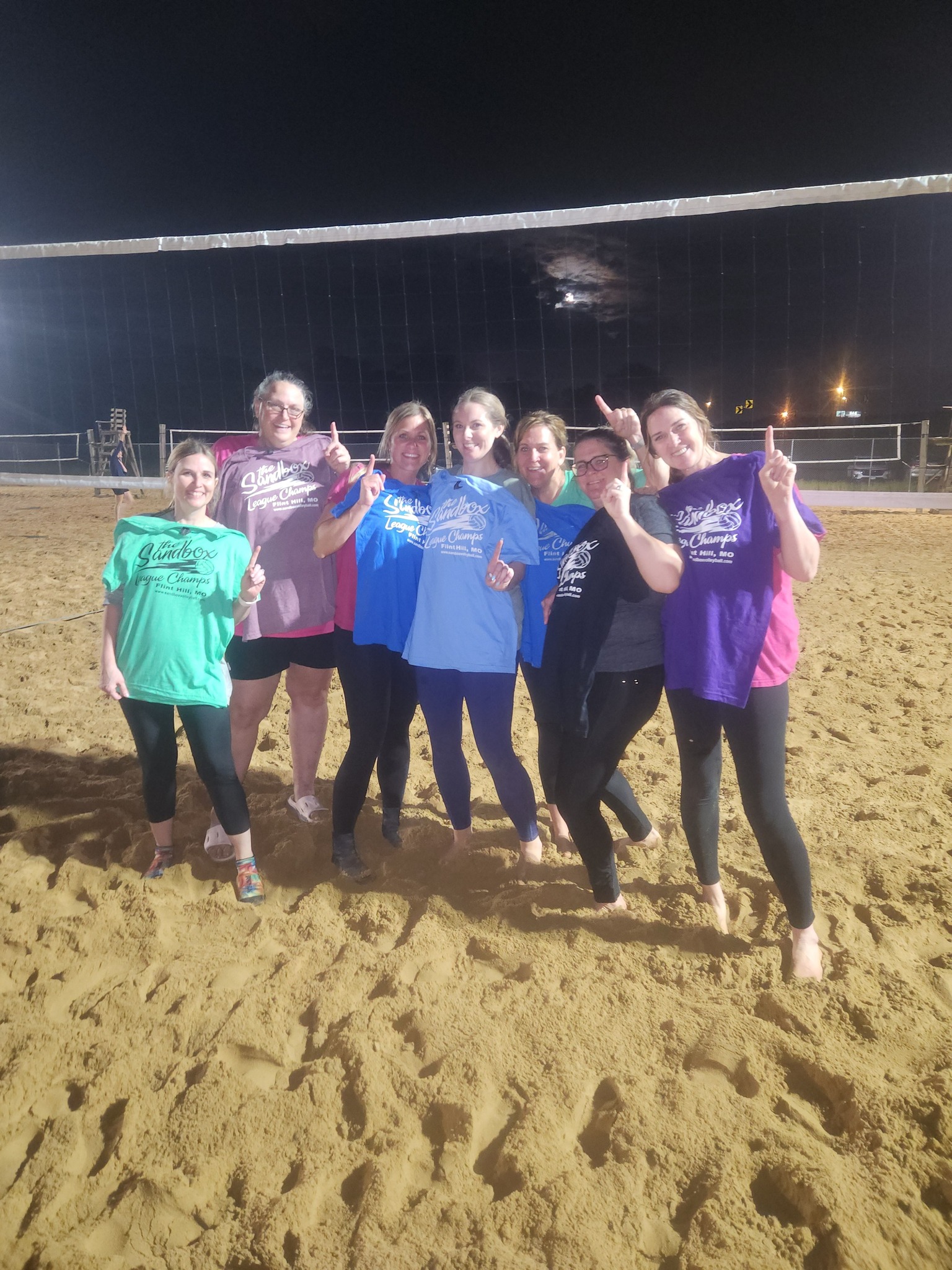 picture of a group of volleyball players wearing the sandbox volleyball logo t-shirts