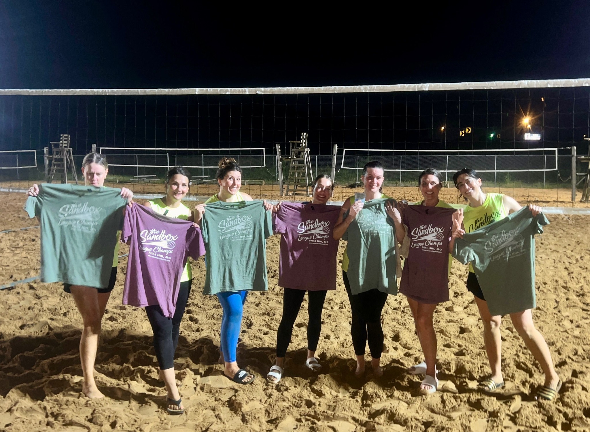 picture of a group of volleyball players wearing the sandbox volleyball logo t-shirts