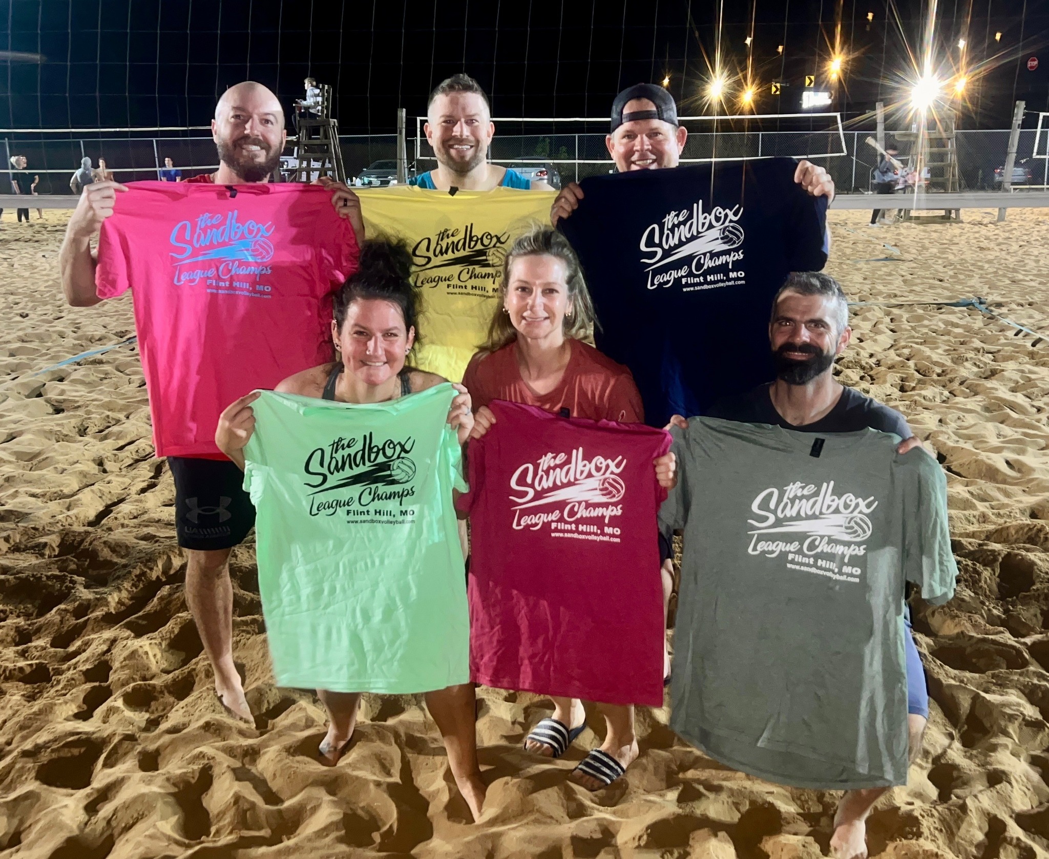 picture of a group of volleyball players wearing the sandbox volleyball logo t-shirts