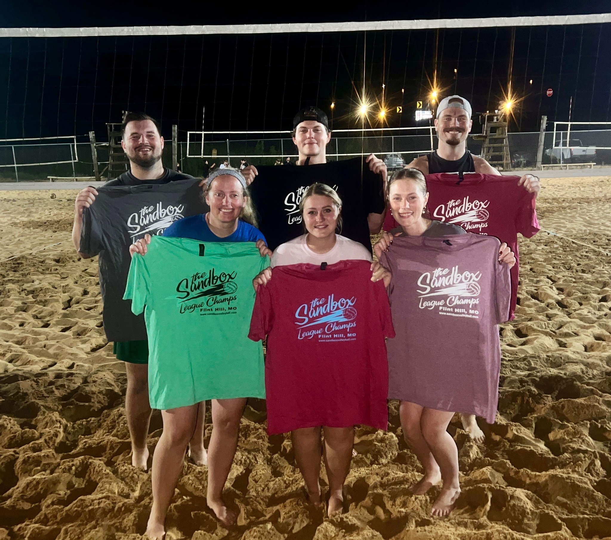 picture of a group of volleyball players wearing the sandbox volleyball logo t-shirts