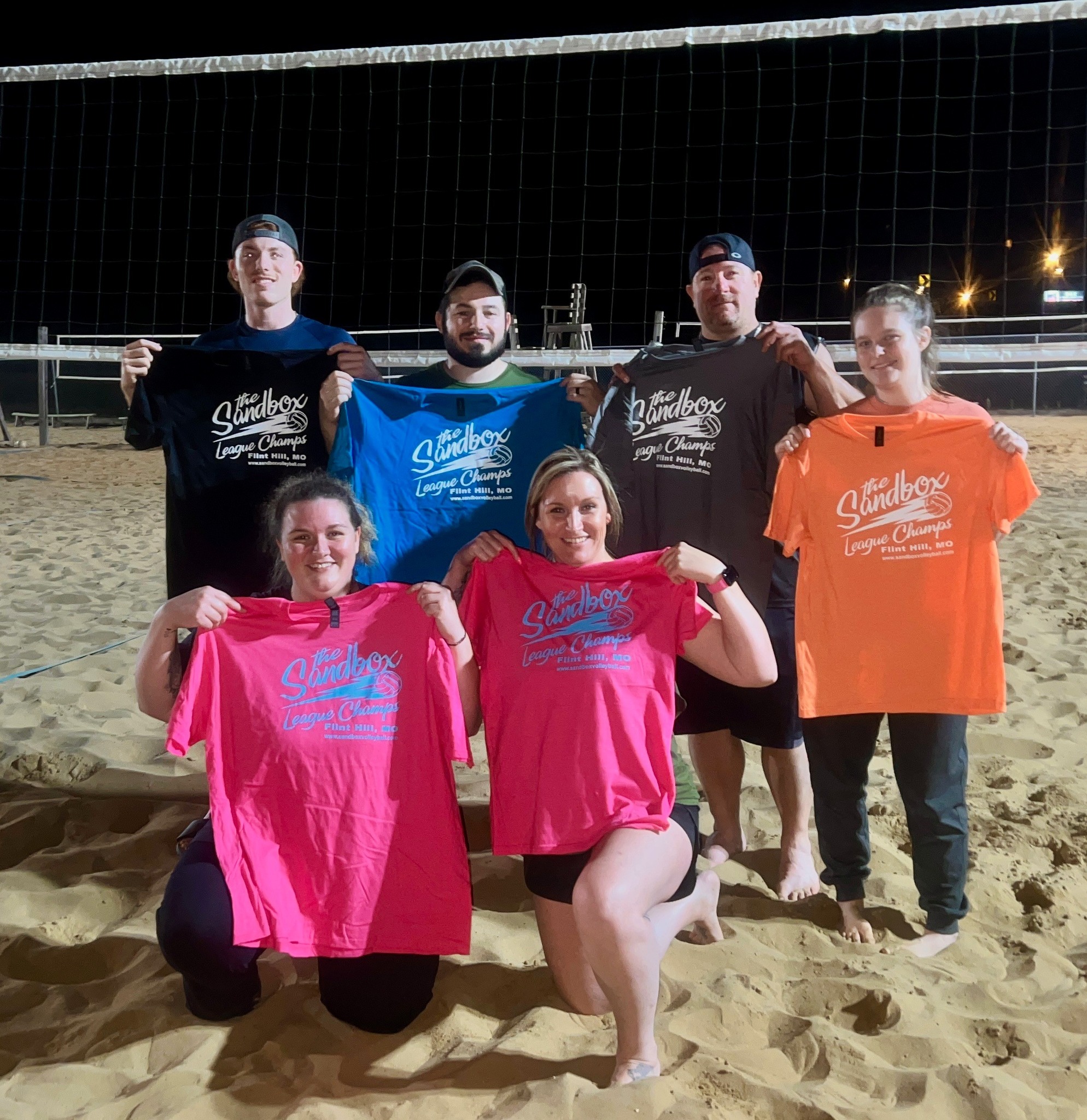 picture of a group of volleyball players wearing the sandbox volleyball logo t-shirts