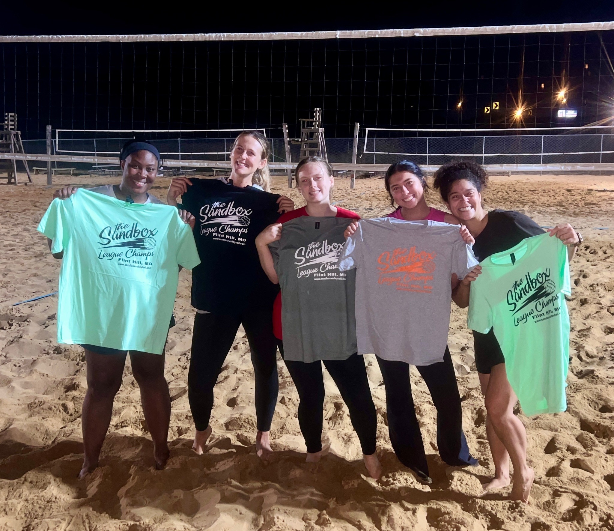 picture of a group of volleyball players wearing the sandbox volleyball logo t-shirts