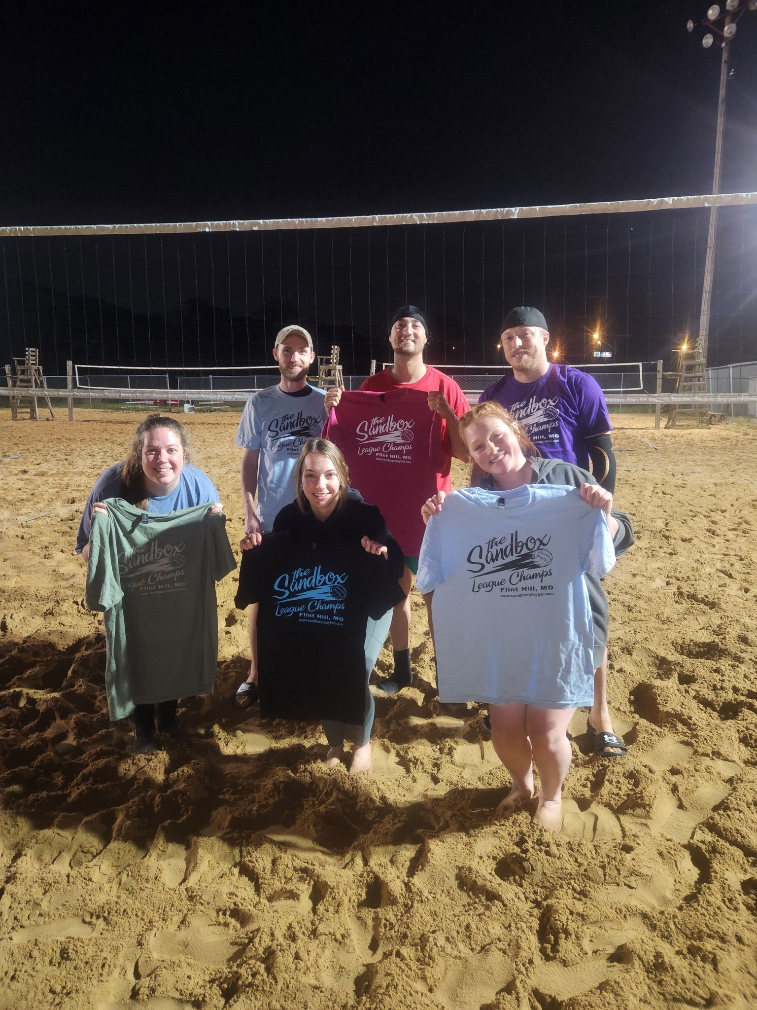 picture of a group of volleyball players wearing the sandbox volleyball logo t-shirts