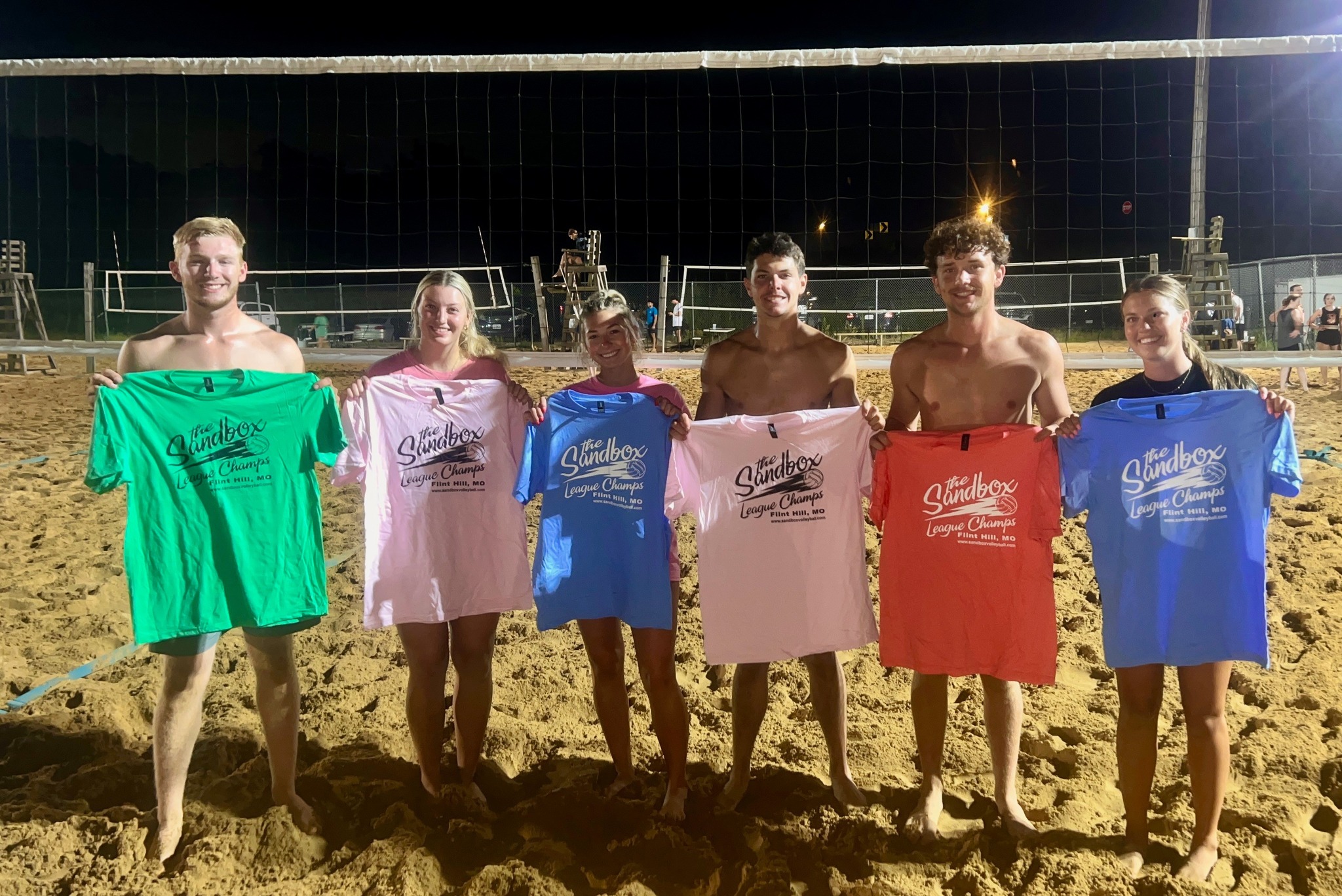 picture of a group of volleyball players wearing the sandbox volleyball logo t-shirts