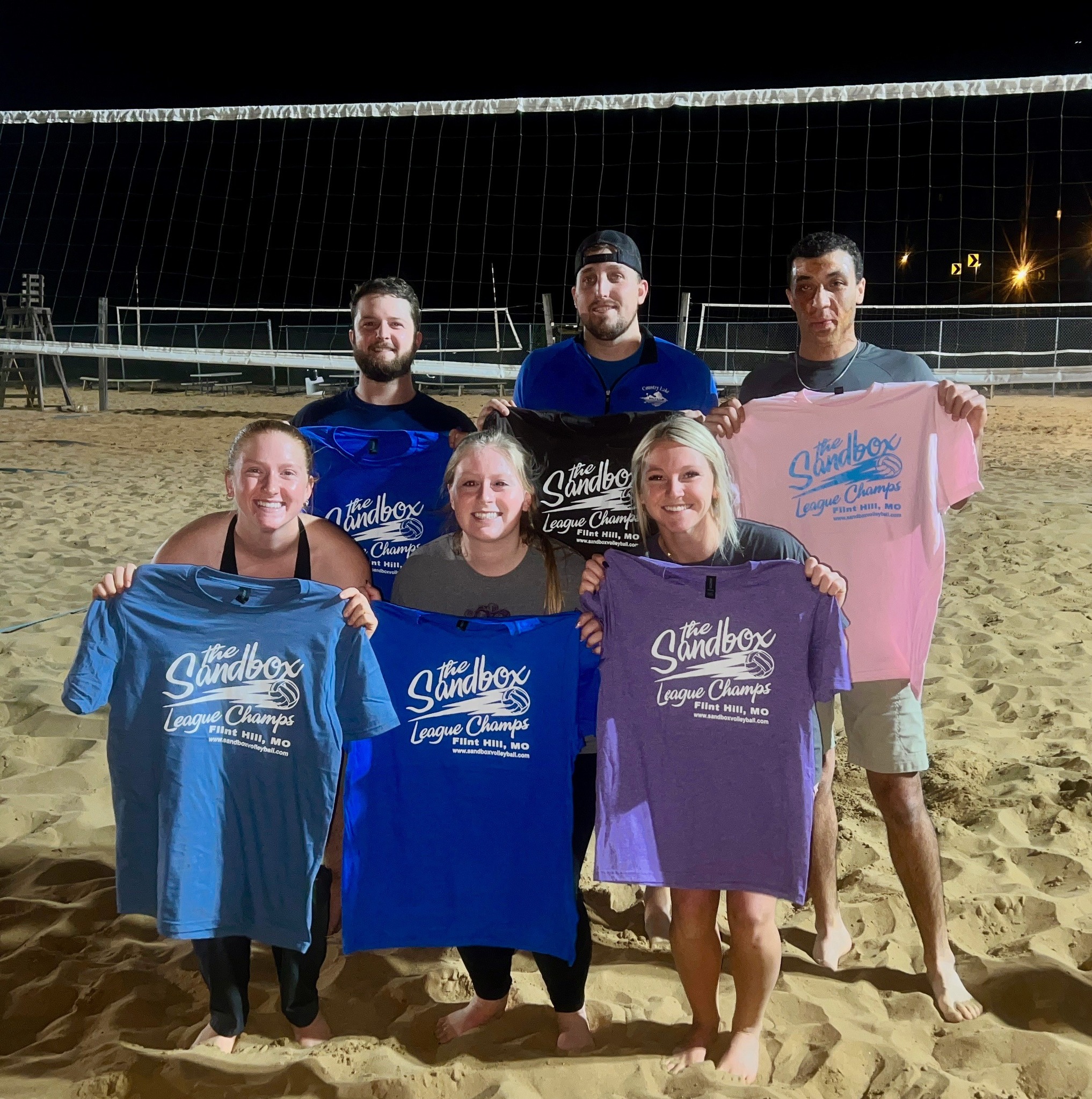 picture of a group of volleyball players wearing the sandbox volleyball logo t-shirts