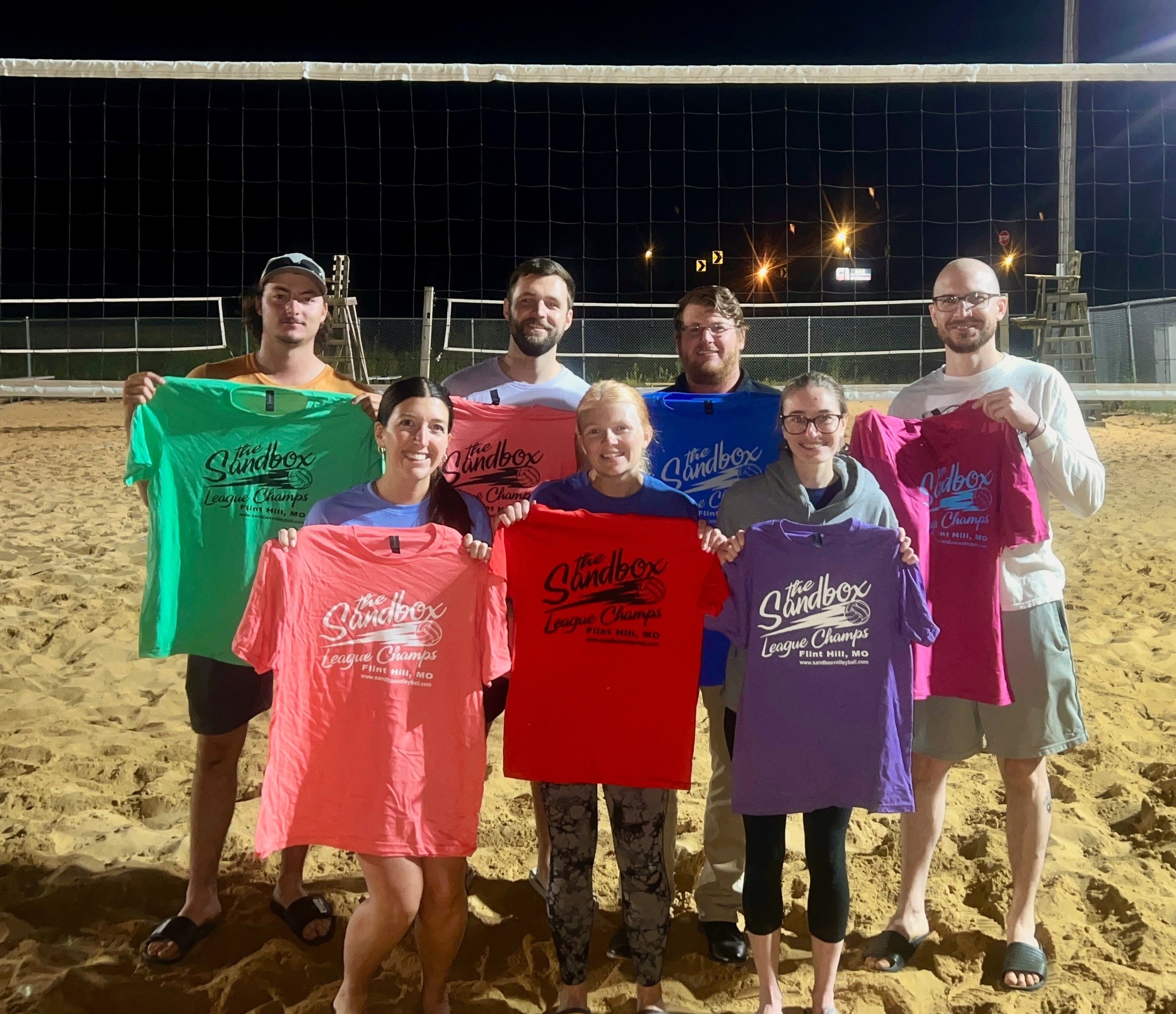 picture of a group of volleyball players wearing the sandbox volleyball logo t-shirts