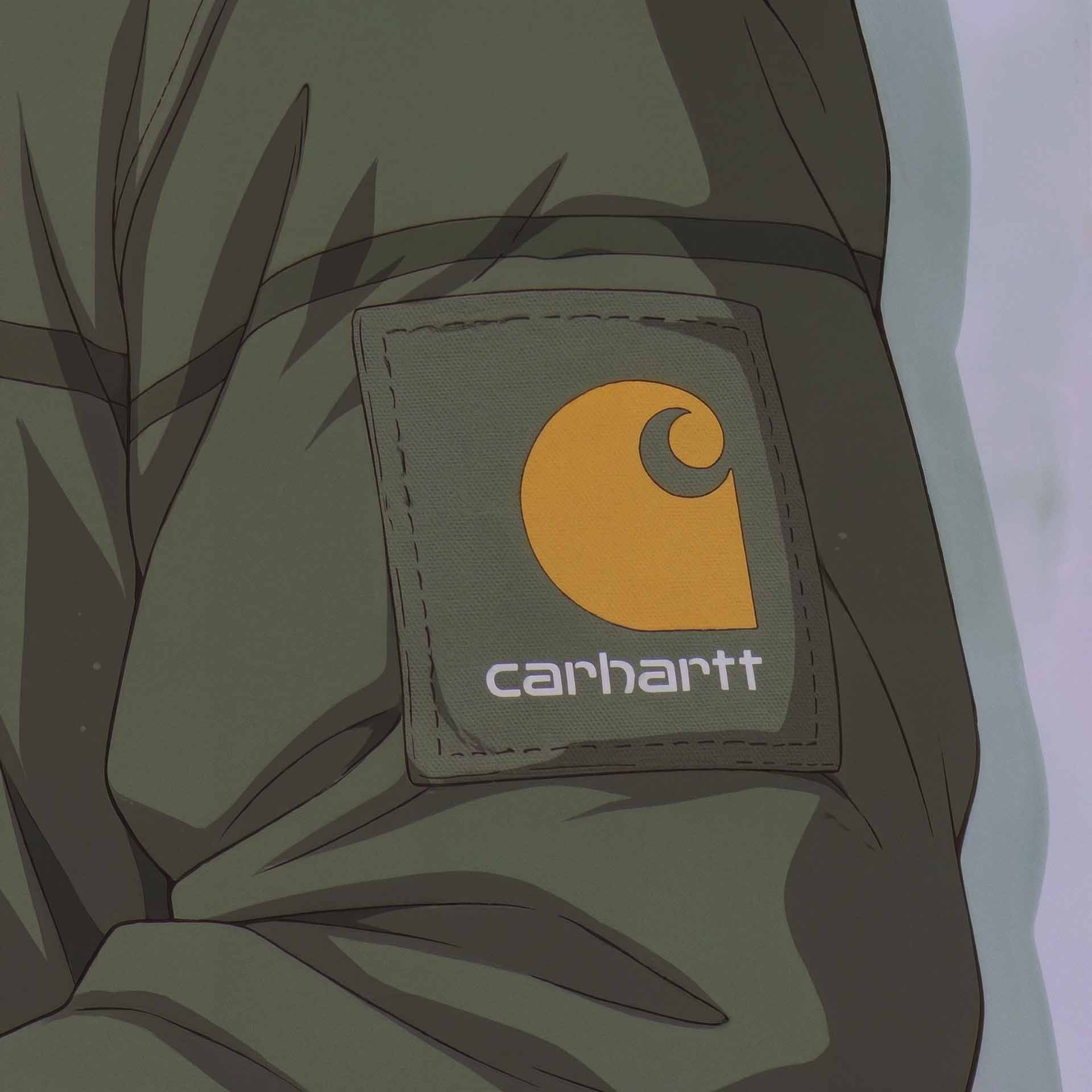 Close-up of a Carhartt logo patch in yellow and white on an olive green jacket sleeve.