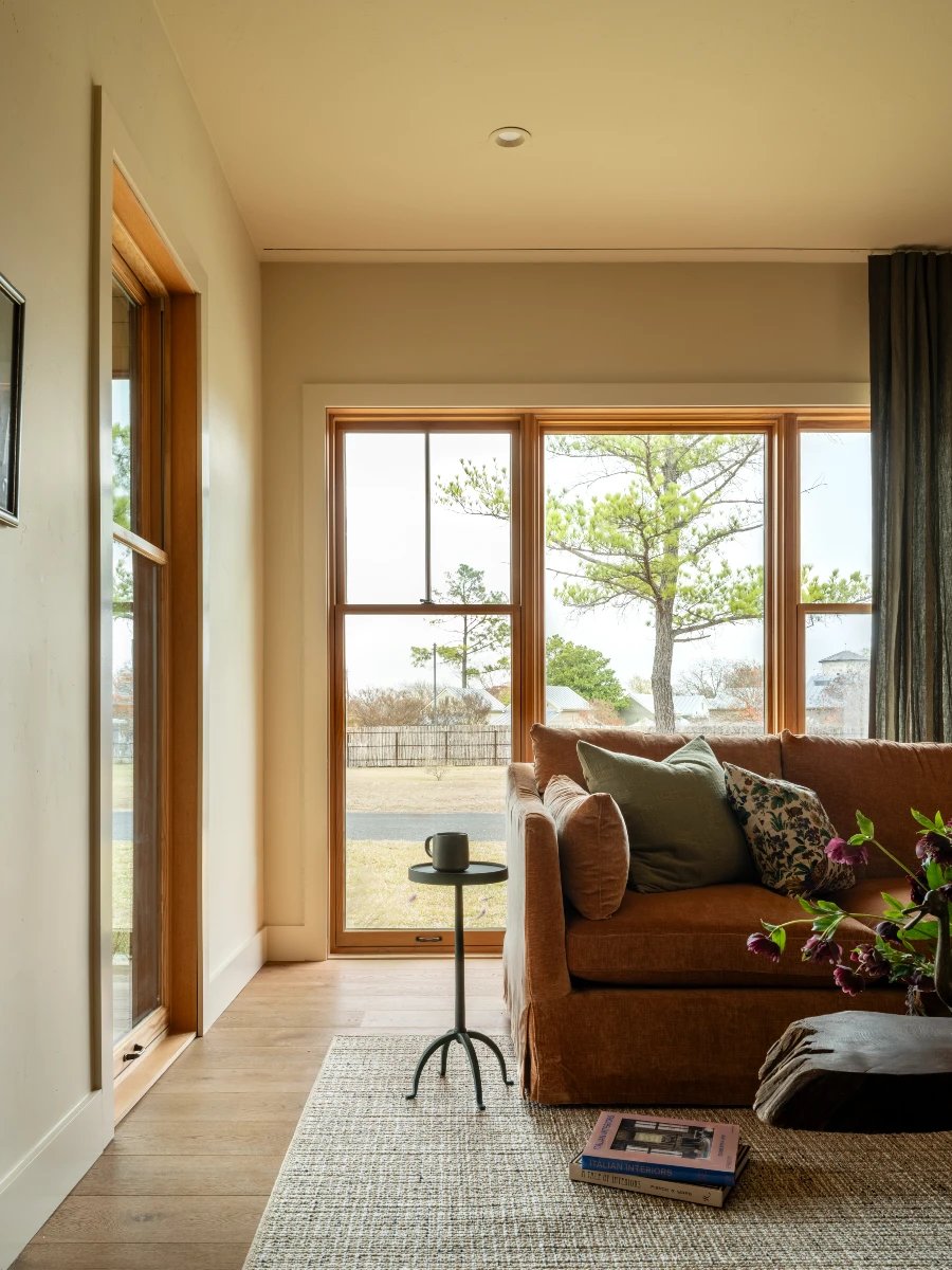 An interior shot with large windows, a couch, a coffee cup