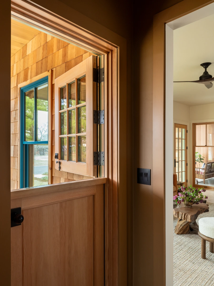 A dutch exterior door with the top half open to the outdoors