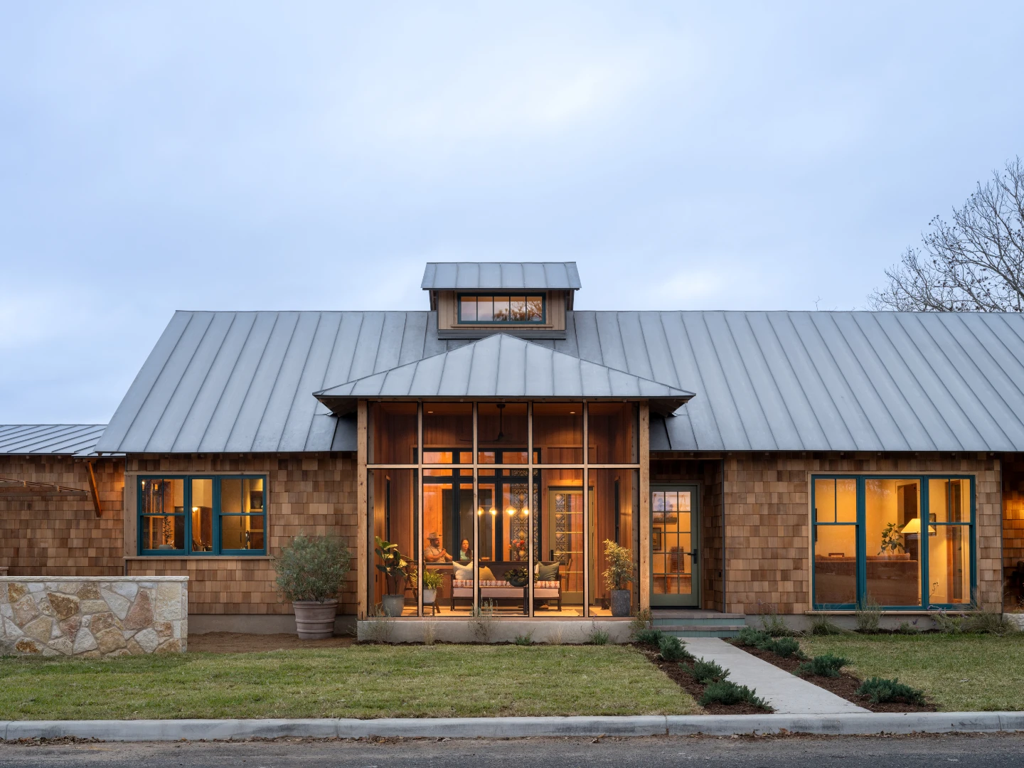 Camp Bluebird house exterior from the front, showcasing a window-lined sunroom