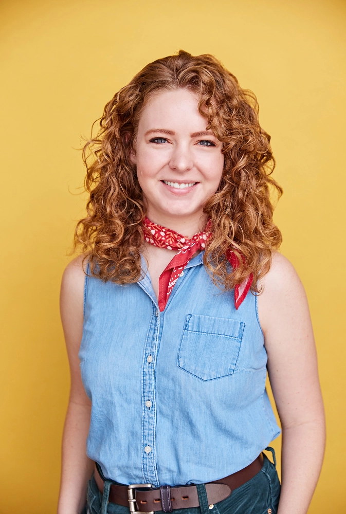 A portrait of Project Designer Becca Floyd wearing a denim shirt and a red bandana