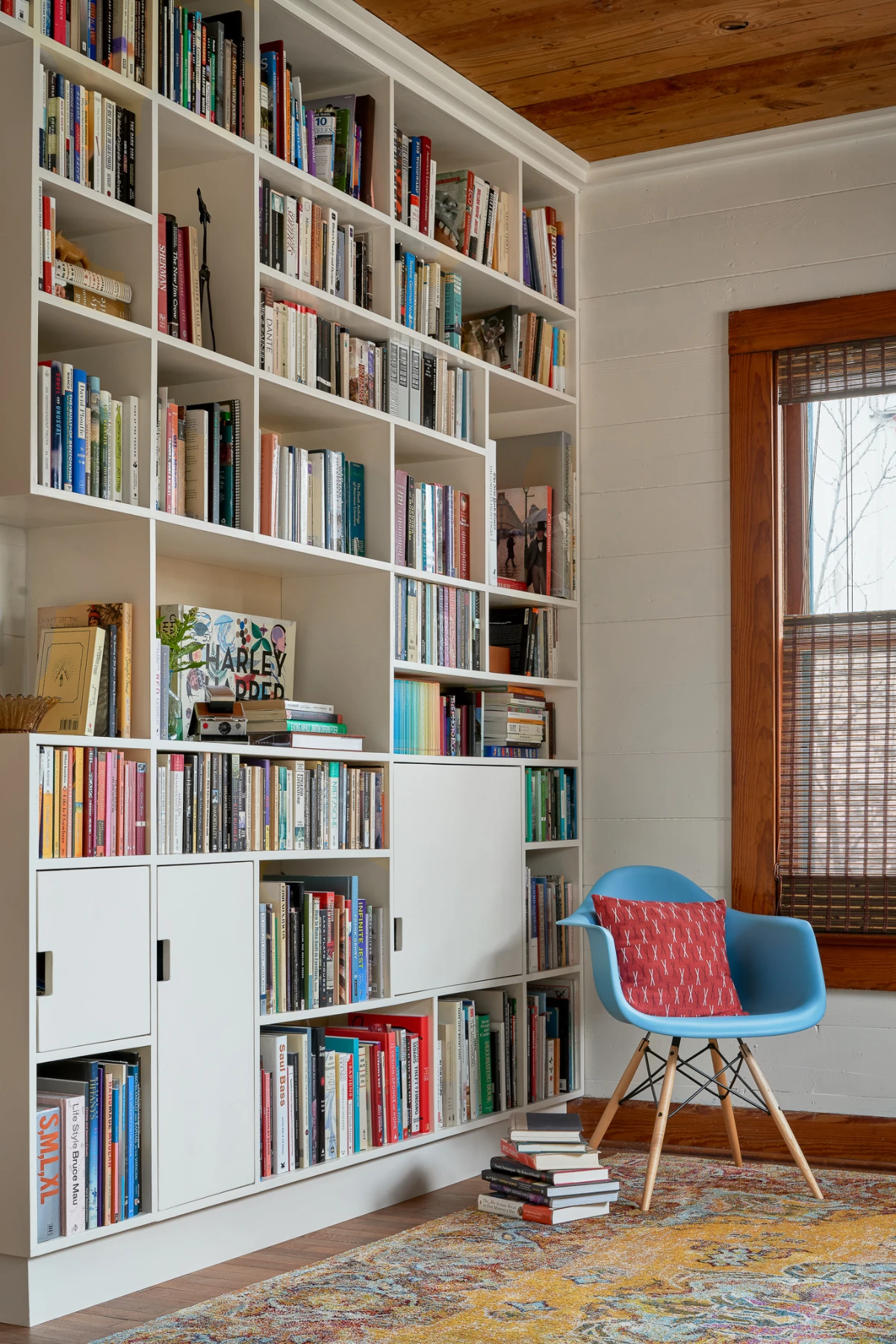 Wende Bungalow's colorful home library, with books organized into modern built-in bookshelves