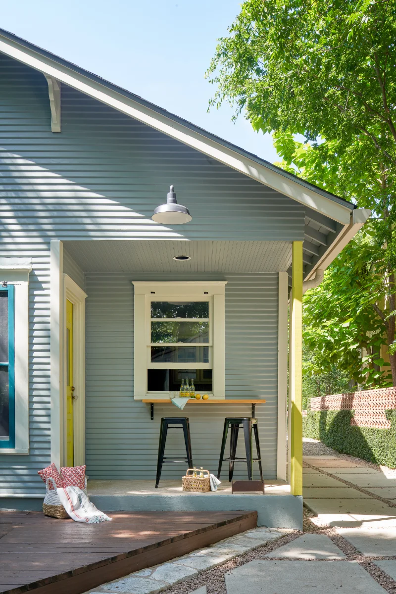 A side view of the Wende Bungalow exterior. A small covered porch leads to an inviting wood deck.