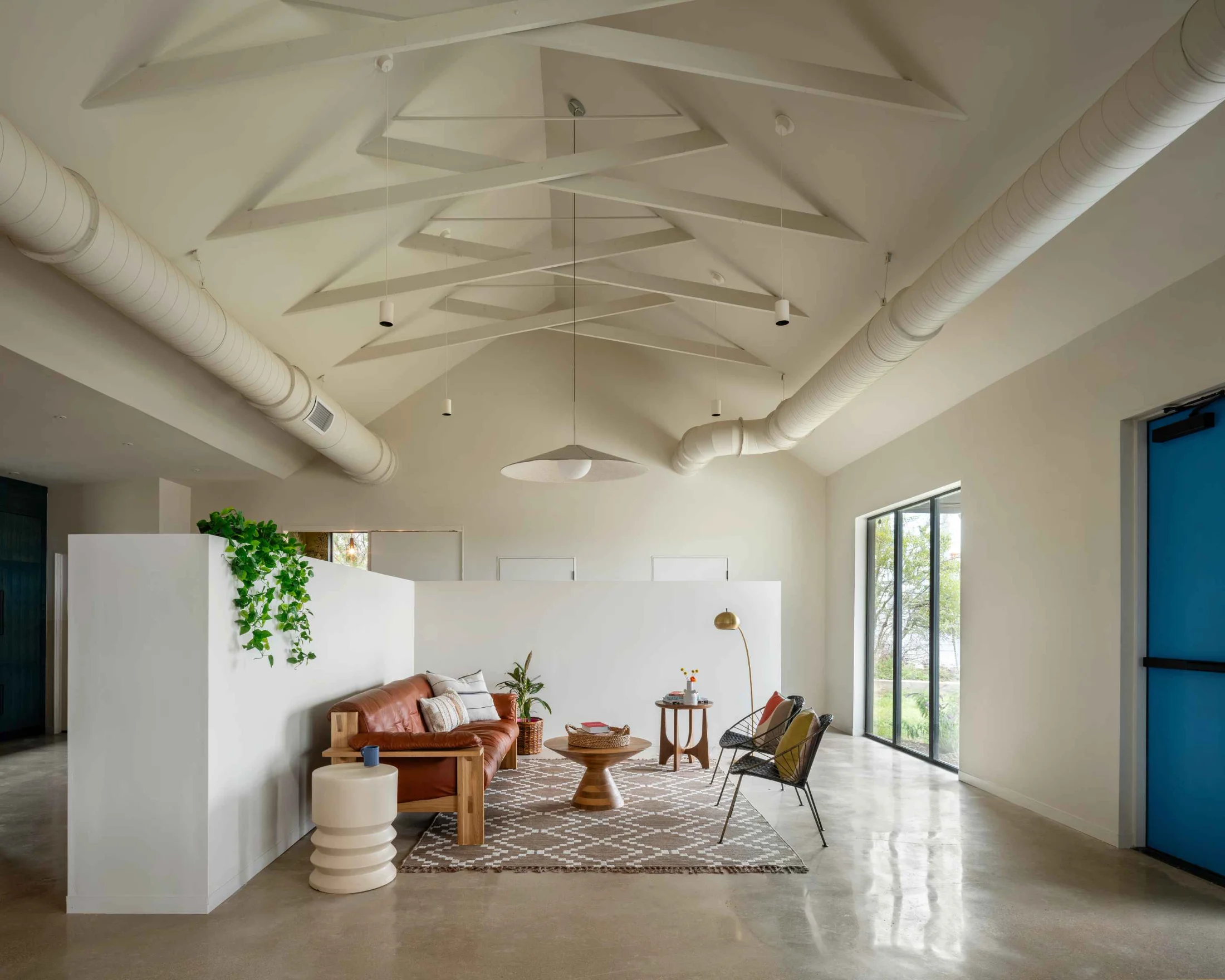 A living space in a corner of the FBG office features modern bohemian furnishings and healthy indoor plants.