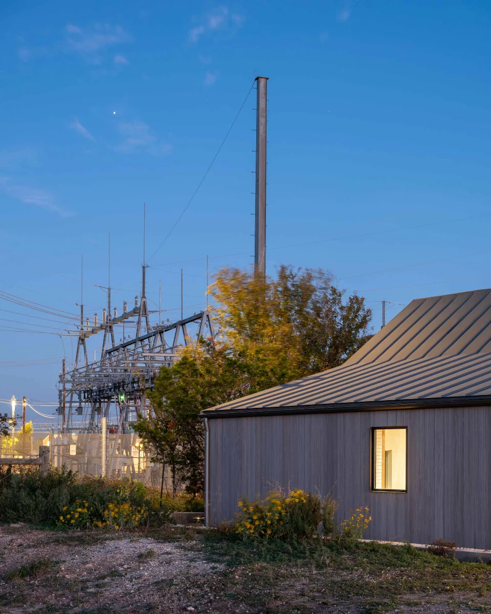 An exterior corner of the FBG Office juts into the foreground of the image. Industrial electrical transformers appear in the background.