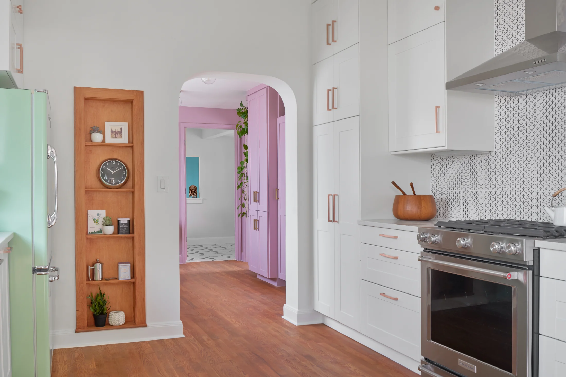 An angle of the Queen Anne House kitchen shows the use of pastels throughout the house. A stainless steel stove sits to the right of the shot.