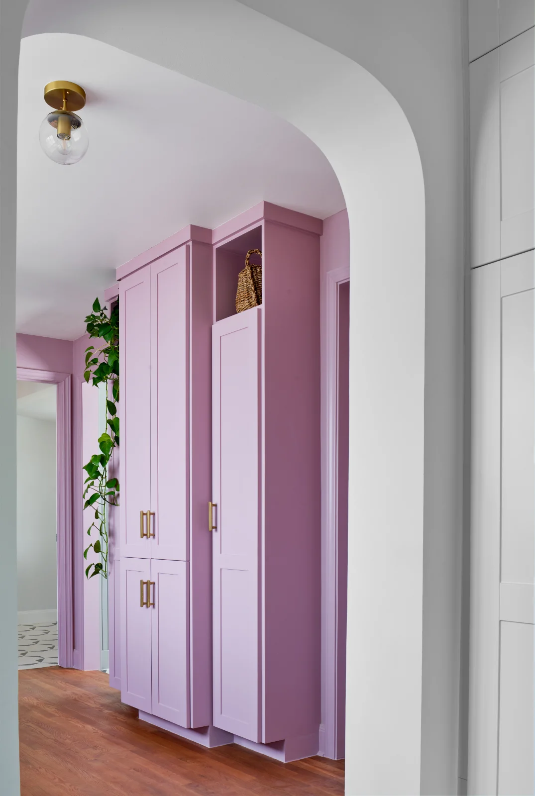 Through a doorway in the Queen Anne House appears built-in wall-to-ceiling cabinetry in a lilac pink hue.