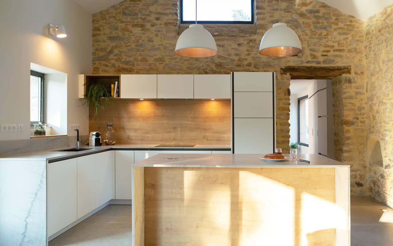 Projet de l'Atelier de Léa : vue frontale d'une cuisine contemporaine minimaliste blanche sur-mesure avec plans de travail en marbre.