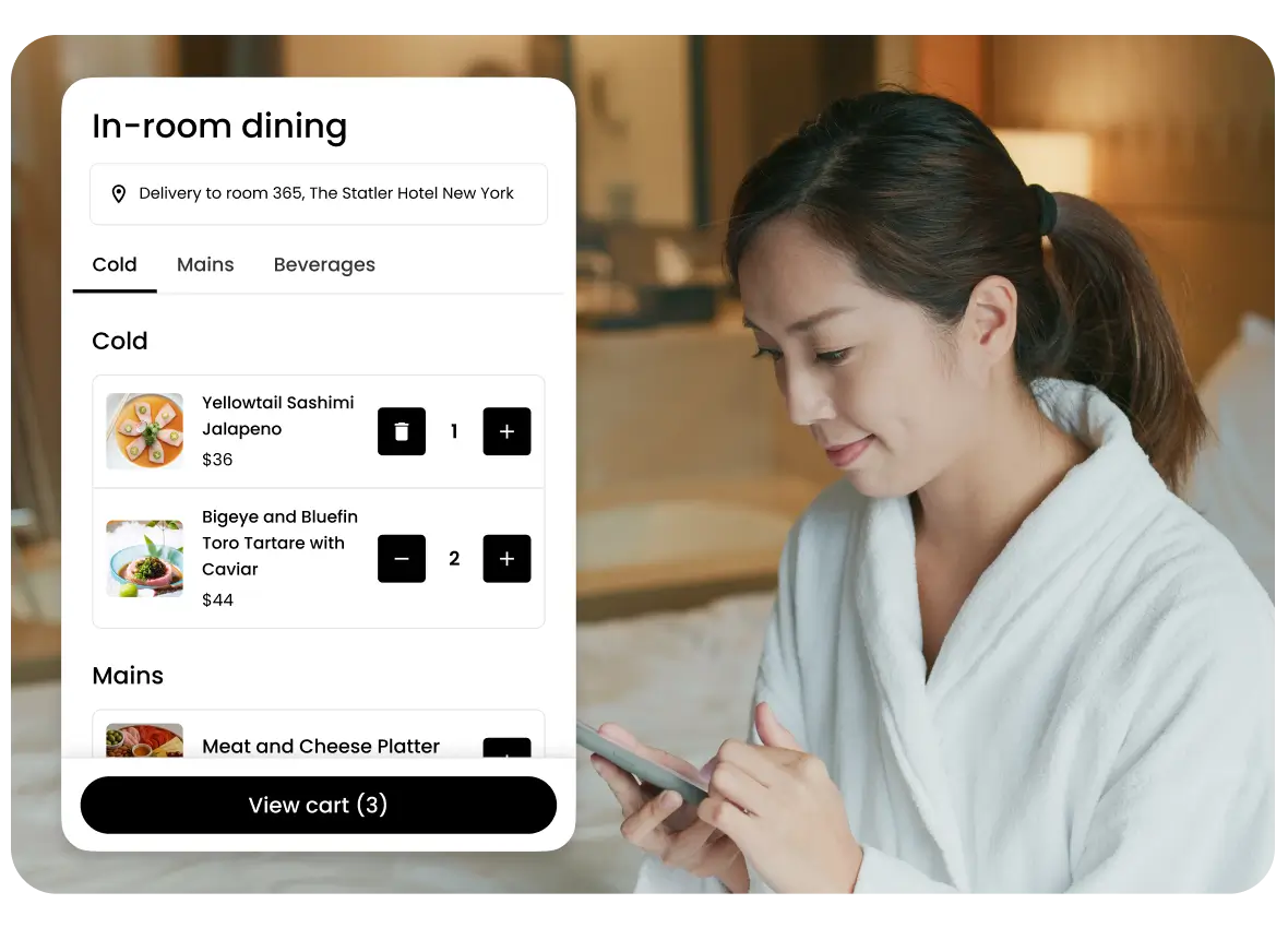 Woman in white robe using a smartphone in a hotel room with in-room dining menu overlay showing sushi and seafood dishes selected for delivery.
