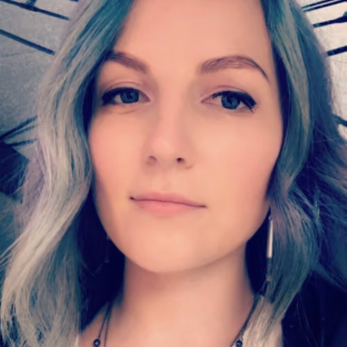 Woman with blonde and blue-gray hair looking directly at camera
