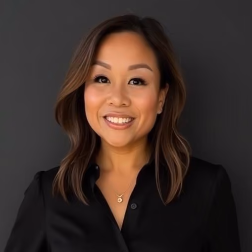 Professional headshot of a woman in black, smiling warmly against gray background