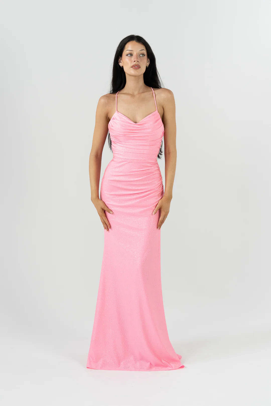 Make a statement in our glamorous Vega formal dress by Tania Olsen Designs, crafted from a soft sparkle knit that hugs your curves in a flattering fitted silhouette. The bodice features a softly draped sash detail that adds texture and elegance, while the V-neckline and delicate spaghetti straps that lace up at the back create a romantic, adjustable fit.