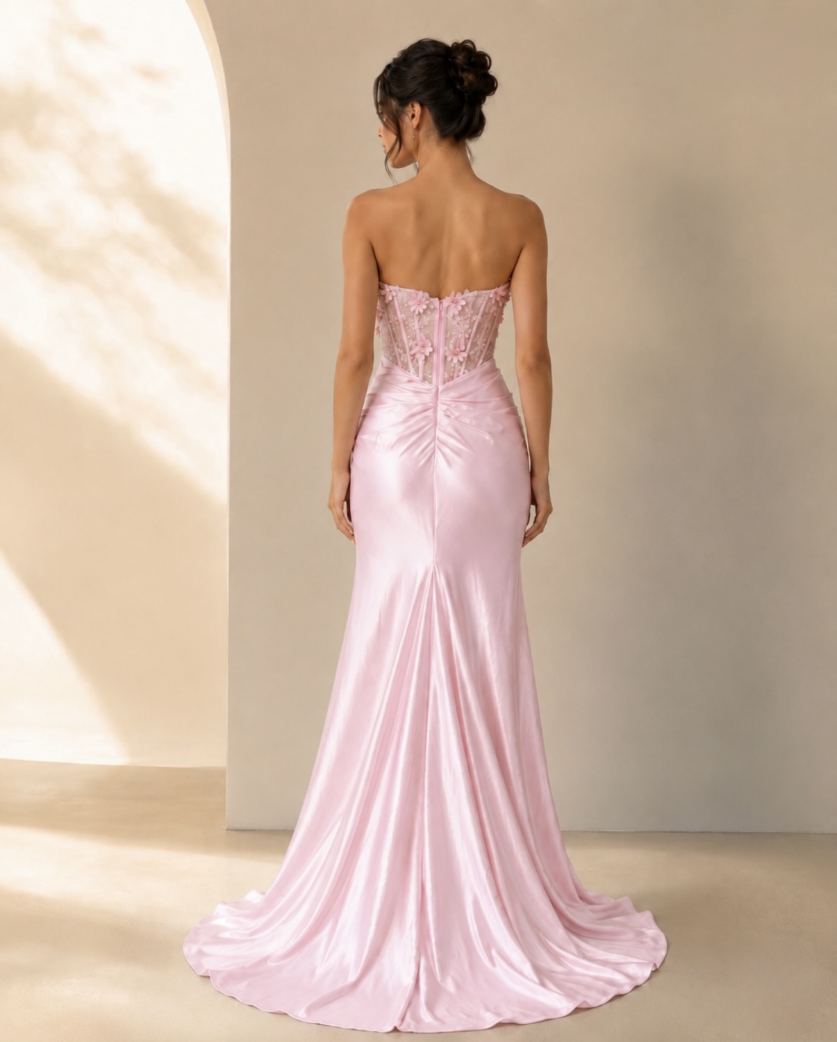 Featuring a structured corset bodice with delicate floral applique, flattering ruching through the waist, a glamorous thjigh-high split and an elegant flowing train.