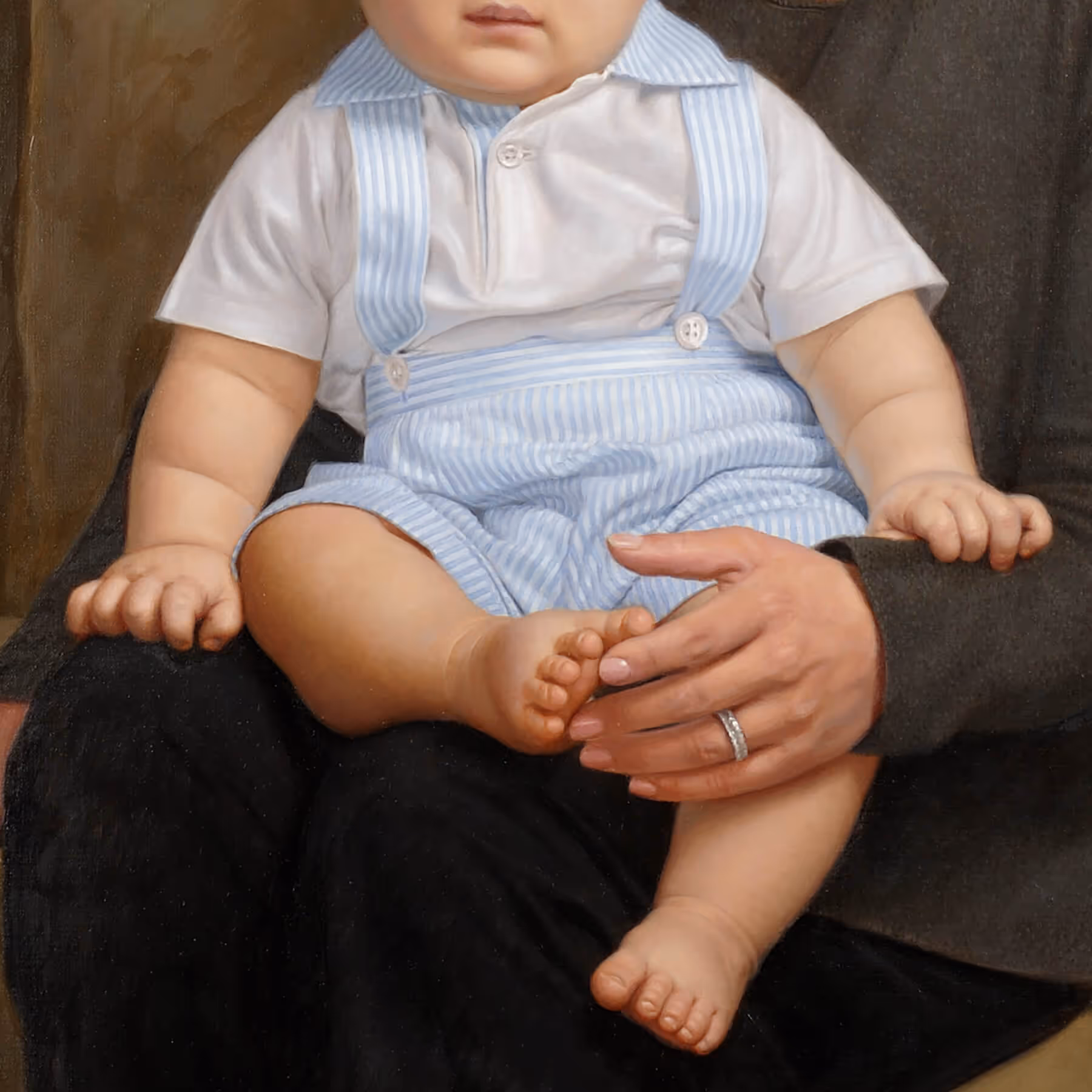 Detail of Hayden’s blue outfit, Tracy’s hand, and the affectionate gesture touching his toes.