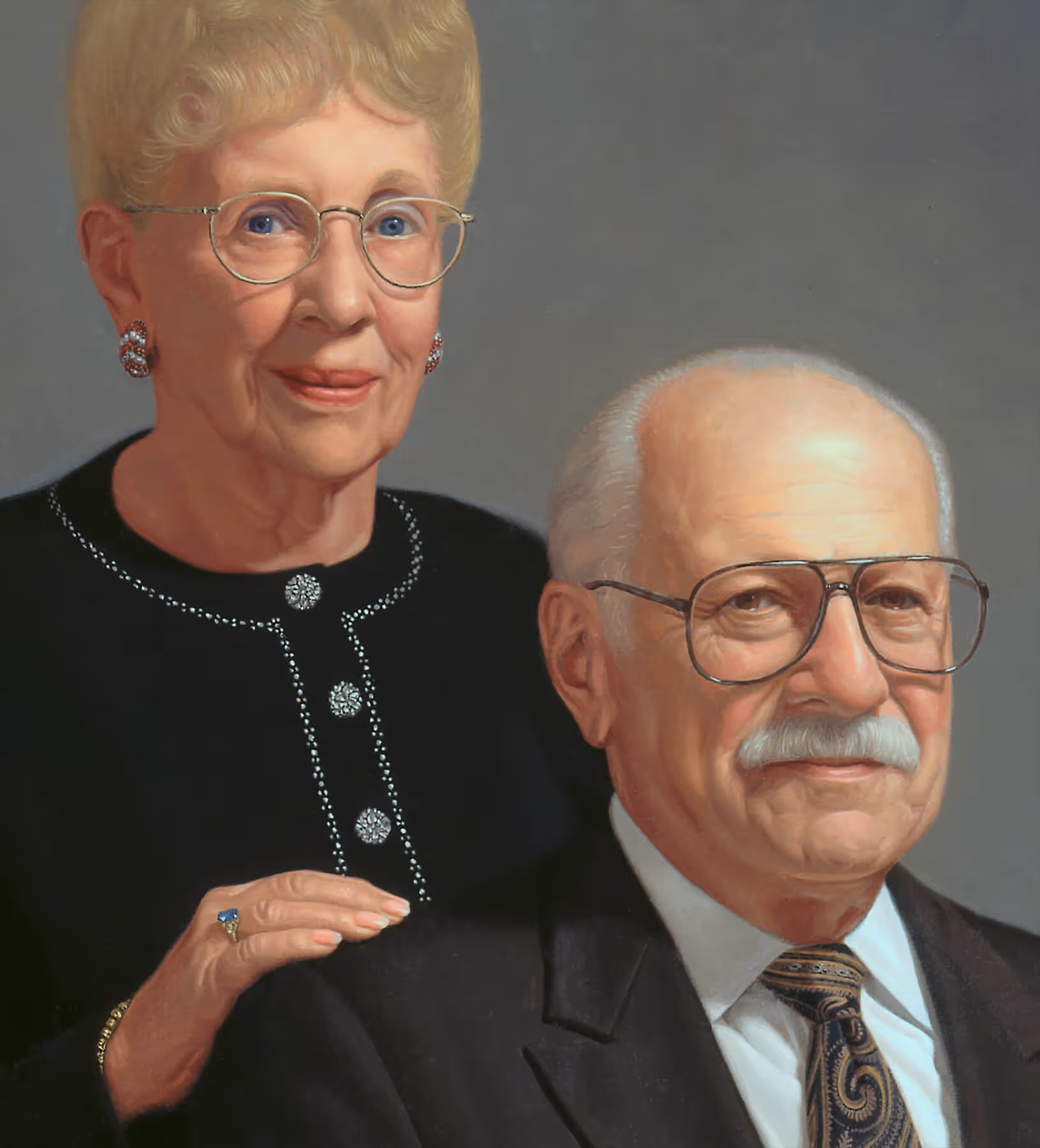 Portrait detail of Joanne and her husband showing facial features, formal attire, and Joanne’s hand resting on his shoulder.