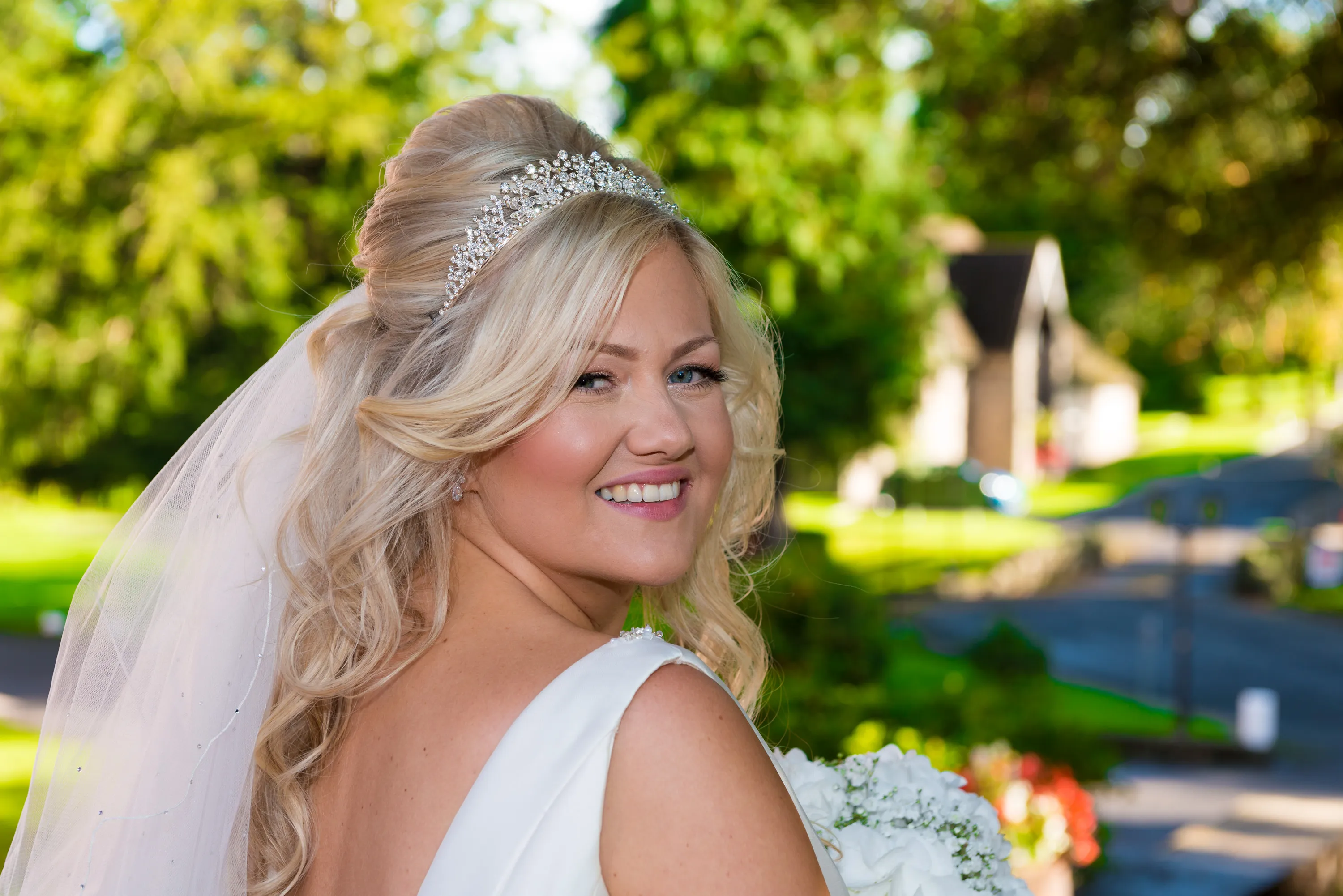 Bride portrait in Cwrt Bleddyn gardens with cottages in background
