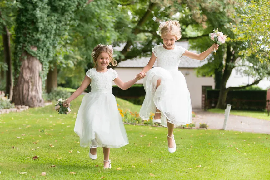 Glen Yr Afon wedding flower girls skipping on lawn