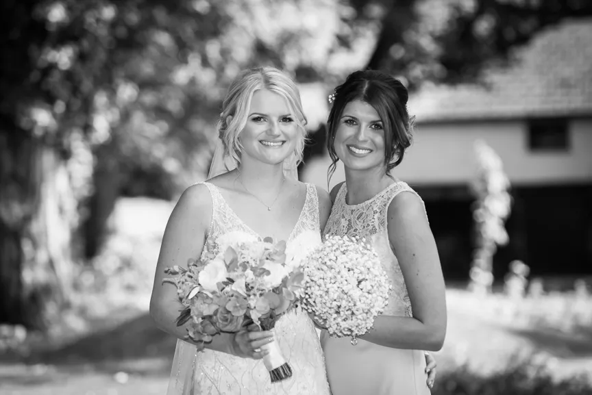 Glen Yr Afon wedding bride and bridesmaid on lawn