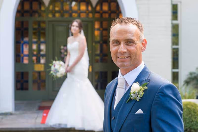 Glen Yr Afon wedding groom with bride in background 