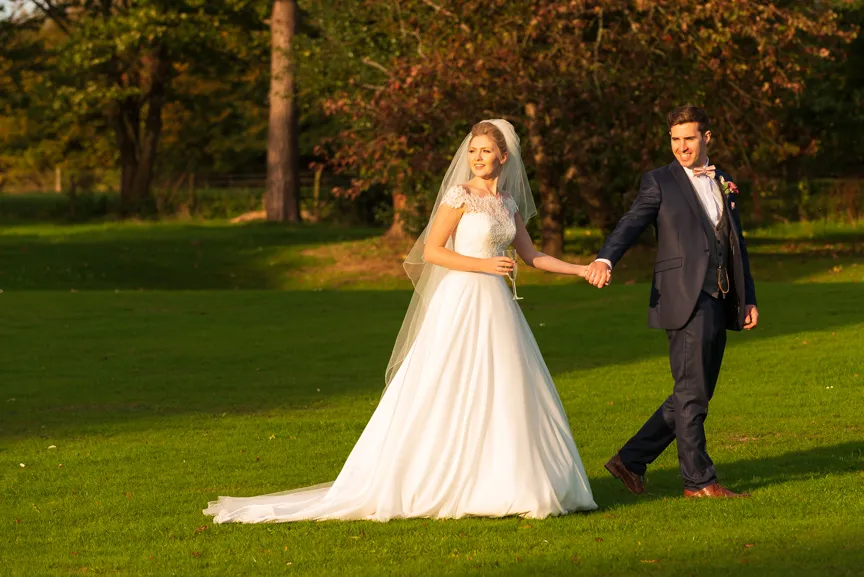 St Tewdrics House wedding bride & groom walking in gardens sunset