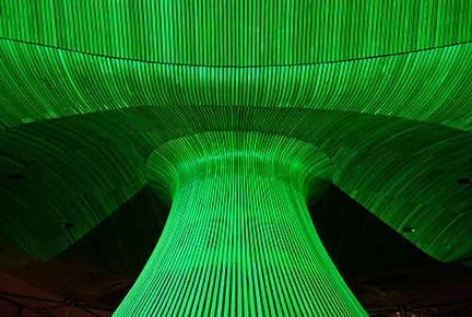 Abstract architectural structure with vertical green light lines converging at a wide base and curving outward at the top.