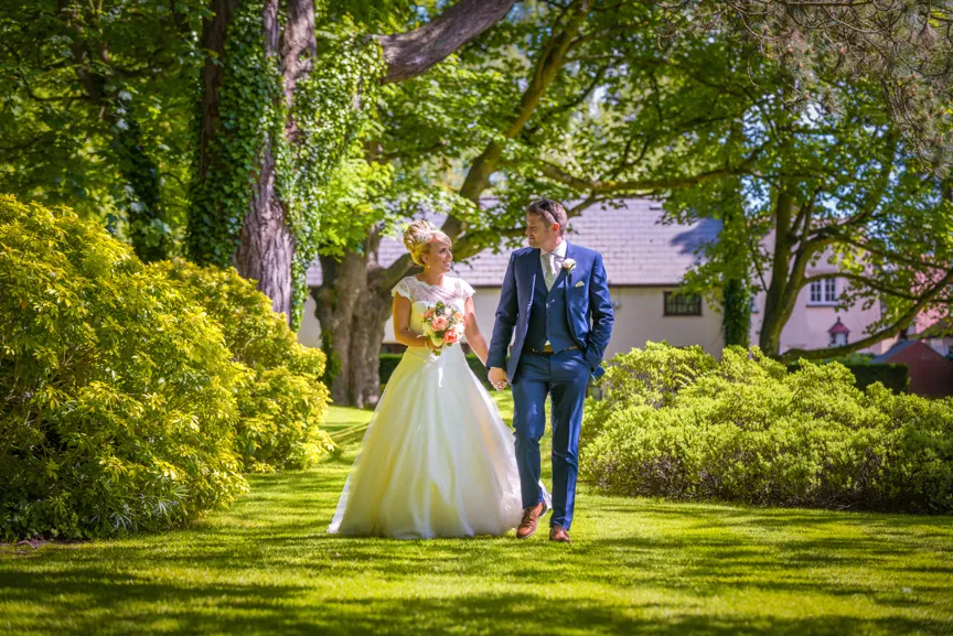 Glen Yr Afon wedding bride & groom walking on lawn
