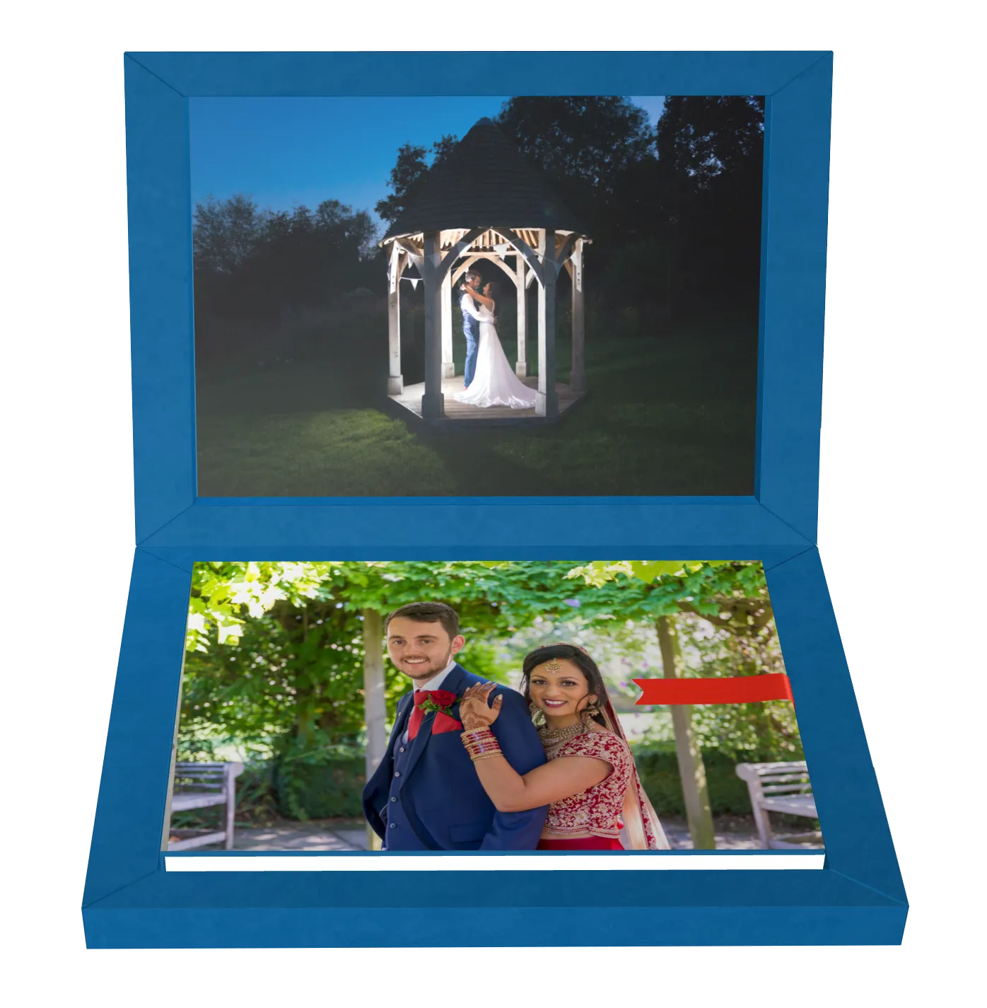A blue open photo album showing a nighttime wedding photo of a couple embracing under a gazebo on the top page and a daytime photo of a smiling bride in traditional Indian attire hugging a groom in a blue suit on the bottom page.