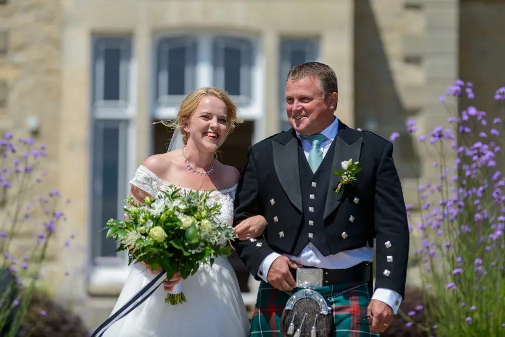 St Tewdrics House outdoor wedding bride & father walking to service