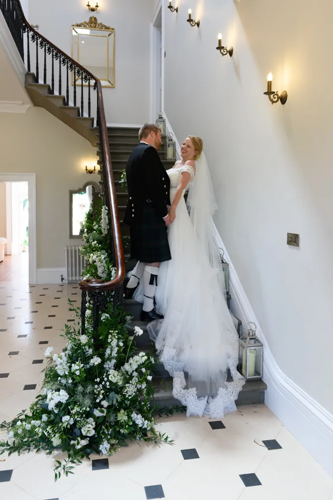 St Tewdrics House wedding bride & groom laughing on stairs