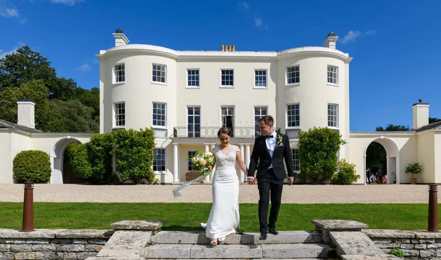 Bride and groom walking in gardens at Rockbeare Manor Exeter