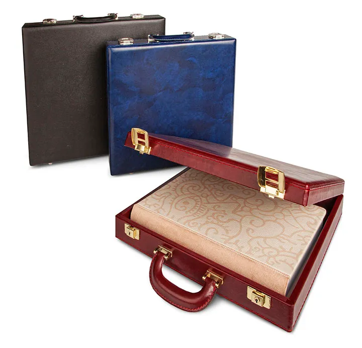 Three leather briefcases in black, blue, and open red showing a beige patterned fabric inside.