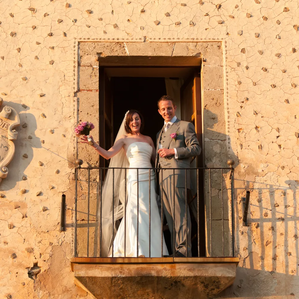 bride and groom waving from balcony at Finca Son Bosch in Majorca by Andrew Hazard, natural wedding photography