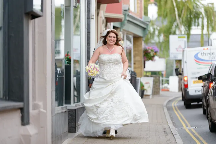 bride smiling as walking through Usk by Andrew Hazard