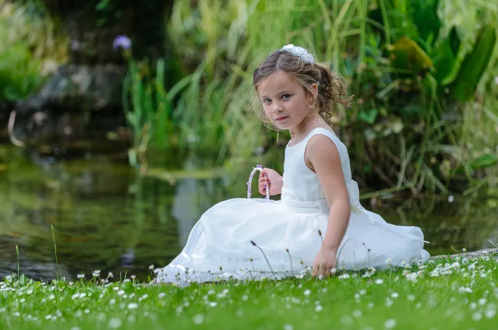 child sitting by pond and daisies at The Manor by Andrew Hazard Photography